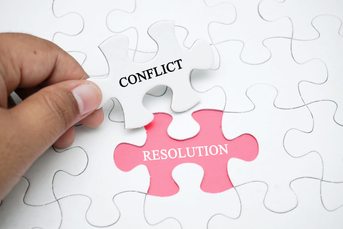 A puzzle piece that says conflict and empty space that says resolution