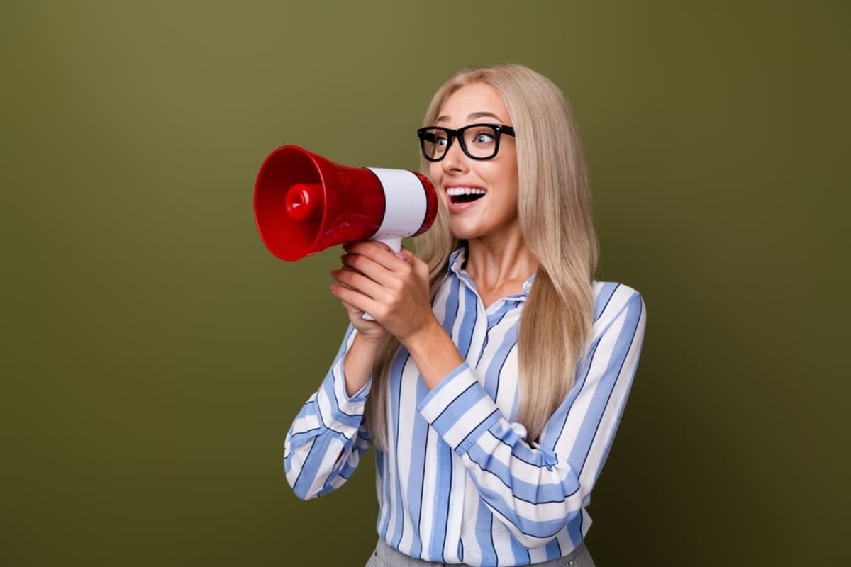 Someone holding a megaphone in front of a yellow background