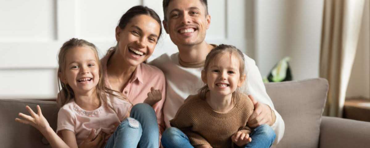 Happy family of four young parents and cute small funny children daughters bonding sit on sofa - c-1