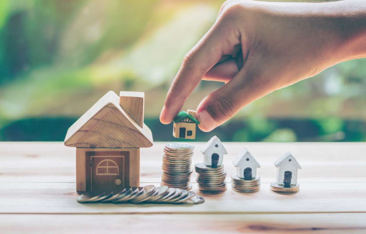 House placed on coins Mens hand is planning savings money of coins to buy a home concept concept for property ladder