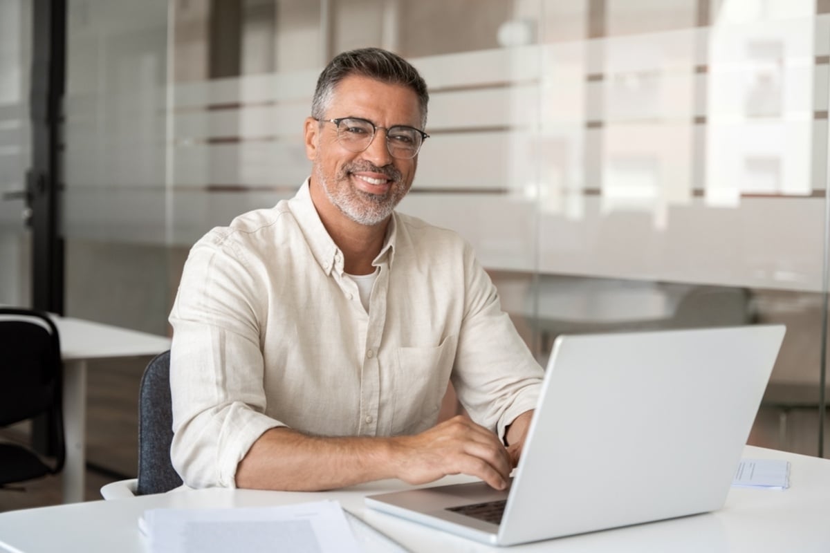 A happy man working on a laptop